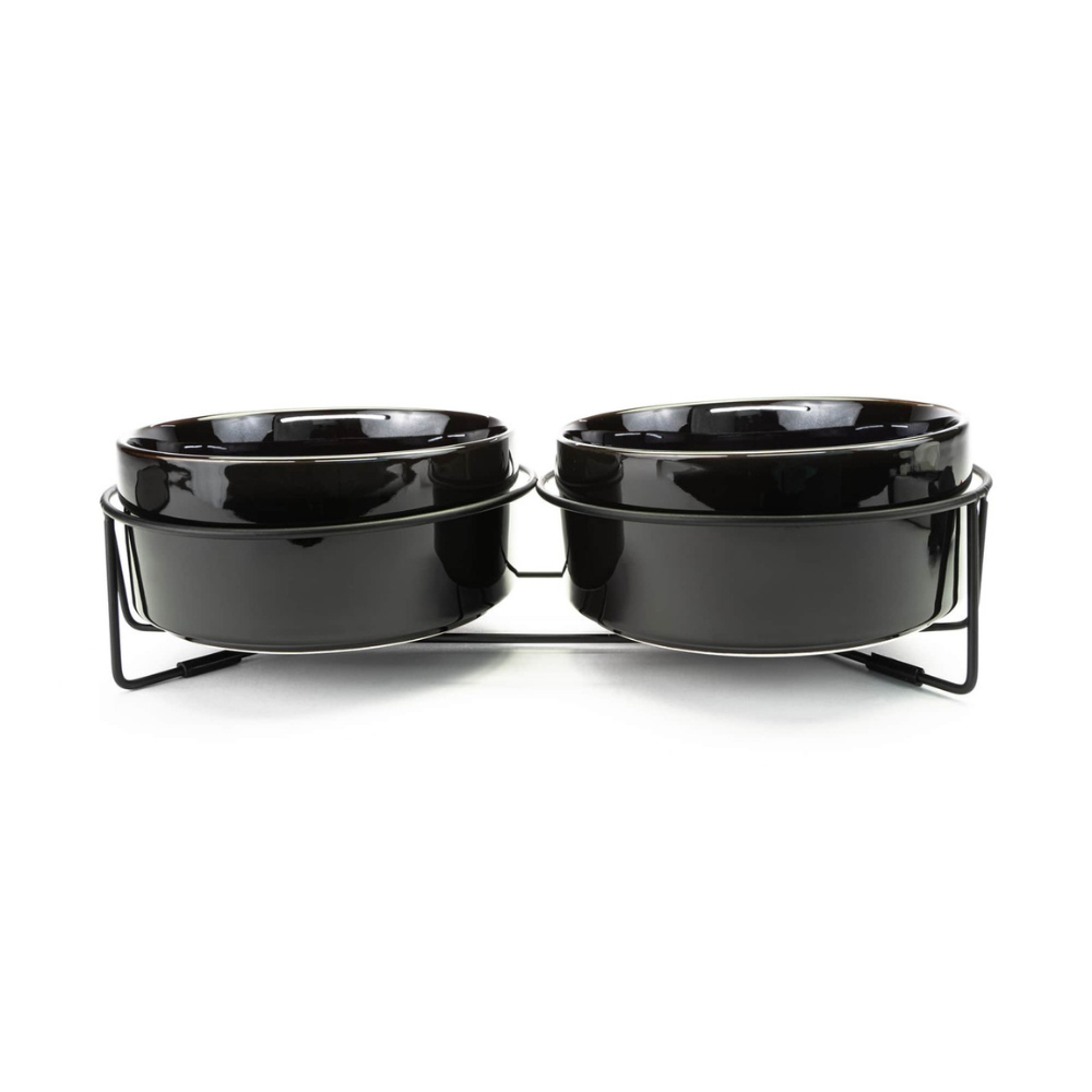 Black ceramic pet bowls on a metal stand against a white background