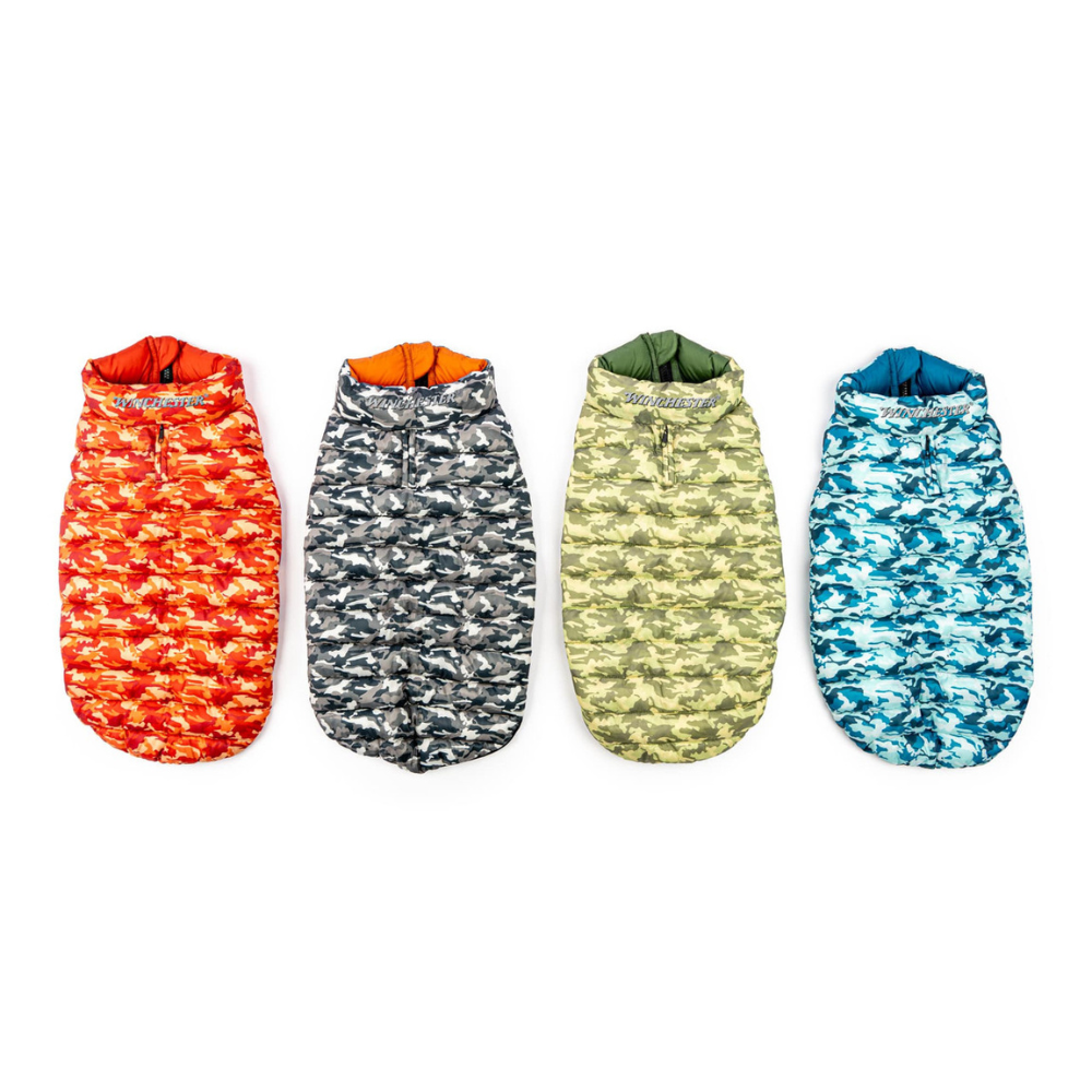 Four colorful puffy vests for dogs with camouflage patterns on a white background
