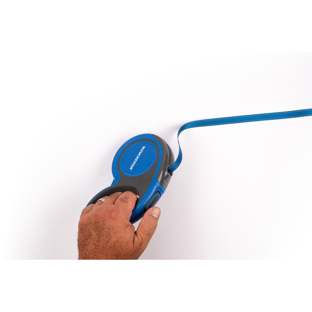 Hand holding a blue and black retractable dog leash on a white background